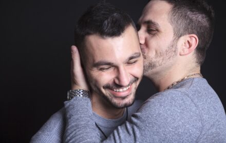 sexual orientation - two men embracing, one kissing the other on the cheek